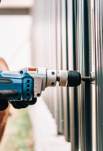 Man working with an electric screwdriver on the construction site