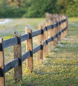 Wooden fence barrier at farm grounds for cattle and territory protection.